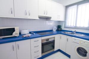 ネルハにあるBAJAMAR II 22 MENYBERのキッチン(白いキャビネット、青いカウンタートップ付)