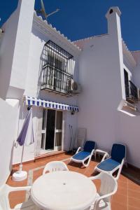 a white patio with a white table and chairs at BAJAMAR II 22 MENYBER in Nerja