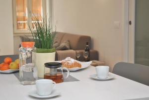 a table with cups and plates of food on it at Casa del Borgo Maria Luisa by Gardadomusmea in Tremosine Sul Garda