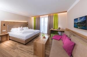 una camera d'albergo con un letto e un divano di Hotel zum Hirschen a Zell am See