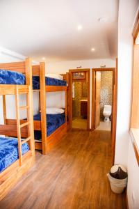 a room with bunk beds and a bathroom at Community Hostel Alausi in Alausí