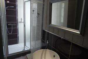 a bathroom with a glass shower and a sink at les volets bleus in Saint-Guénolé