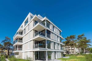 an apartment building with balconies and a blue sky at Villa Vogue Gretas Beach Home in Binz