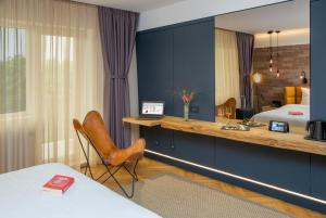 a hotel room with a desk and a bed at Caro Hotel in Bucharest