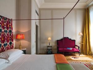 una camera con letto e sedia rossa di Antica Torre Di Via Tornabuoni 1 a Firenze