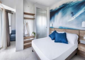a bedroom with a large bed with blue pillows at Hotel Meeting in Riccione