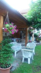 un patio con bancos blancos y flores rosas en Casa Hostal Olga - Castilla y León, en Cofiñal