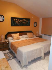 1 dormitorio con 1 cama grande y una pintura en la pared en Casa Hostal Olga - Castilla y León, en Cofiñal