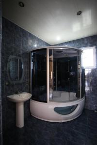 a bathroom with a large shower and a sink at Talo's Guest House in Makhinjauri