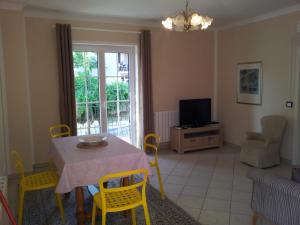 a living room with a table and chairs and a television at Apartment Luiza Funtana in Funtana
