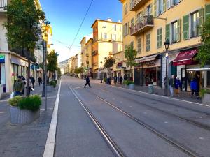 an empty street with a train track in a city at Résidence Barla in Nice