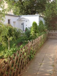 una valla de madera frente a una casa blanca en BerLietz en Berlín