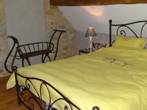 a bedroom with a large bed and a chair at Au Cocon d'Avoine in Hamois
