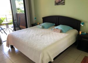 a bed in a room with a white bedspread at Casa del Toucan in Dominical