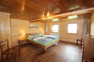 1 dormitorio con 1 cama en una cabaña de madera en Les Mourriaux, en Château-d'Oex