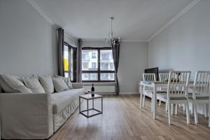een woonkamer met een witte bank en een tafel bij City Apartments Centrum in Warschau