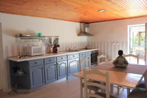 a kitchen with blue cabinets and a wooden table at Vivenda Mendes in Outeiro