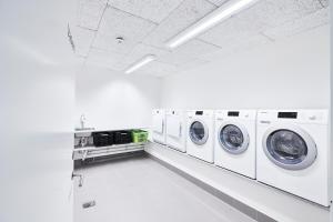 uma lavandaria branca com máquinas de lavar roupa brancas em athome apartments em Aarhus