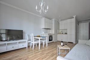 een woonkamer met een bank en een tafel met stoelen bij City Apartments Centrum in Warschau