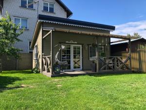 a small house with a porch and a patio at Naujos statybos namelis in Palanga