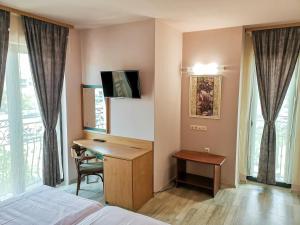 a hotel room with a desk and a bed at Empera H-l in Sunny Beach