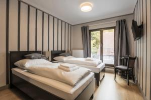 una habitación de hotel con 2 camas y una silla en Hotel Mandát en Hradištko
