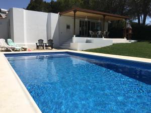 a large blue swimming pool in front of a house at Villa Zen in Albufeira