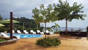 a patio with white chairs and a swimming pool at Apartment Peky in Rab