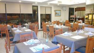 a restaurant with tables and chairs with blue tablecloths at Hotel Escala Uno in Santo Tomé