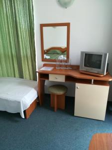 a bedroom with a desk with a computer and a mirror at Guesthouse Ruskovi in Ravda