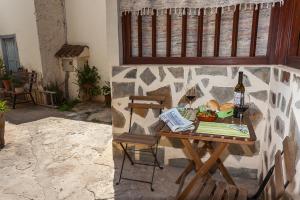 a table with a bottle of wine and wine glasses at Casa Rural La Casa Baja in Santa Lucía
