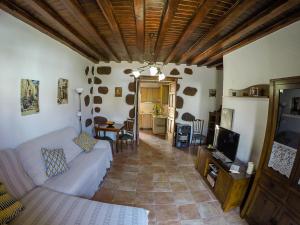 a living room with a couch and a tv at Casa Rural La Casa Baja in Santa Lucía