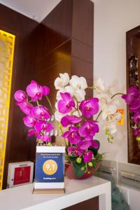 a table with two vases with purple and white flowers at Phu Tho Da Lat Hotel in Da Lat