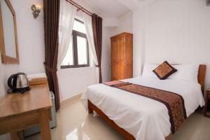 Postel nebo postele na pokoji v ubytování Phu Tho Da Lat Hotel