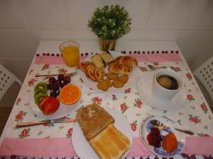 a table topped with plates of breakfast foods and a cup of coffee at Casa da Pedralva in Nazaré