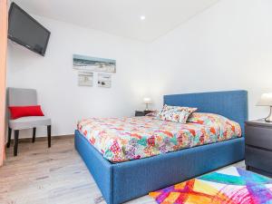 アルブフェイラにあるcasa laranjinha nº2のベッドルーム(カラフルな毛布付きの青いベッド1台付)