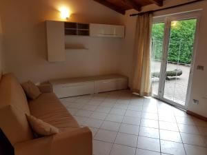 a living room with a couch and a window at Agriturismo Campo dei Fiori in Rancio Valcuvia