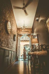 a woman standing in a hallway with a clock on the wall at The Clock Hostel & Suites in Cartagena de Indias