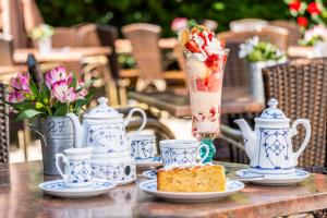 a table topped with cups and plates with a drink at Hotel Pharisäerhof - DAS Hundehotel auf Nordstrand mit Restaurant und Café in Nordstrand