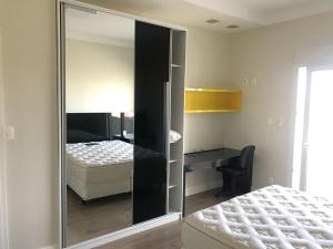 een slaapkamer met een spiegel naast een bed bij Casa 450m2 Laguna Internacional in Laguna +56 foto's