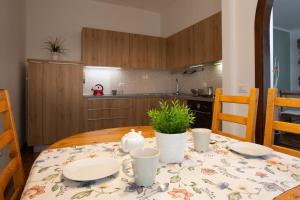 una mesa con platos y tazas en la cocina en Dolce Casa, en Bormio