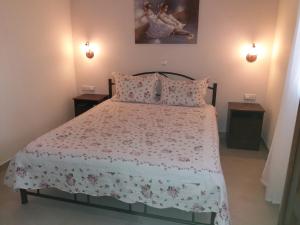 a bedroom with a bed with a floral bedspread at Villa Anna in Ayios Nikolaos Sithonia