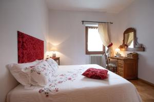 een slaapkamer met een wit bed met een rood hoofdeinde bij Dolce Casa in Bormio