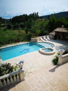 a swimming pool in a yard with chairs around it at gîte de la Rose in Draguignan