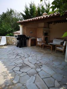 a patio with a grill and a table and chairs at gîte de la Rose in Draguignan