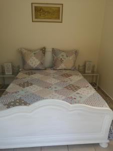 ein Schlafzimmer mit einem Bett mit einer Decke und Kissen in der Unterkunft gîte de la Rose in Draguignan