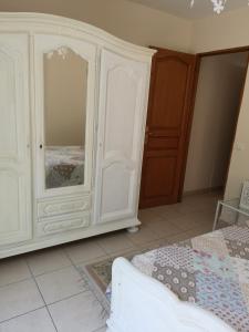 a bedroom with a large white cabinet with a mirror at gîte de la Rose in Draguignan