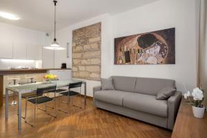a living room with a couch and a table and a kitchen at Flats4Rent Casa Sailù in Verona