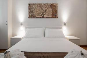 a bedroom with a white bed with two night stands at Flats4Rent Casa Sailù in Verona