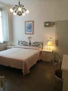 1 dormitorio con cama y lámpara de araña en Villa la Fonte, en Marina di Pietrasanta